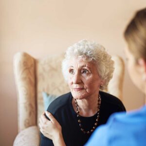 Older couple sharing a meal in a bright assisted living apartment with walking aids nearby.